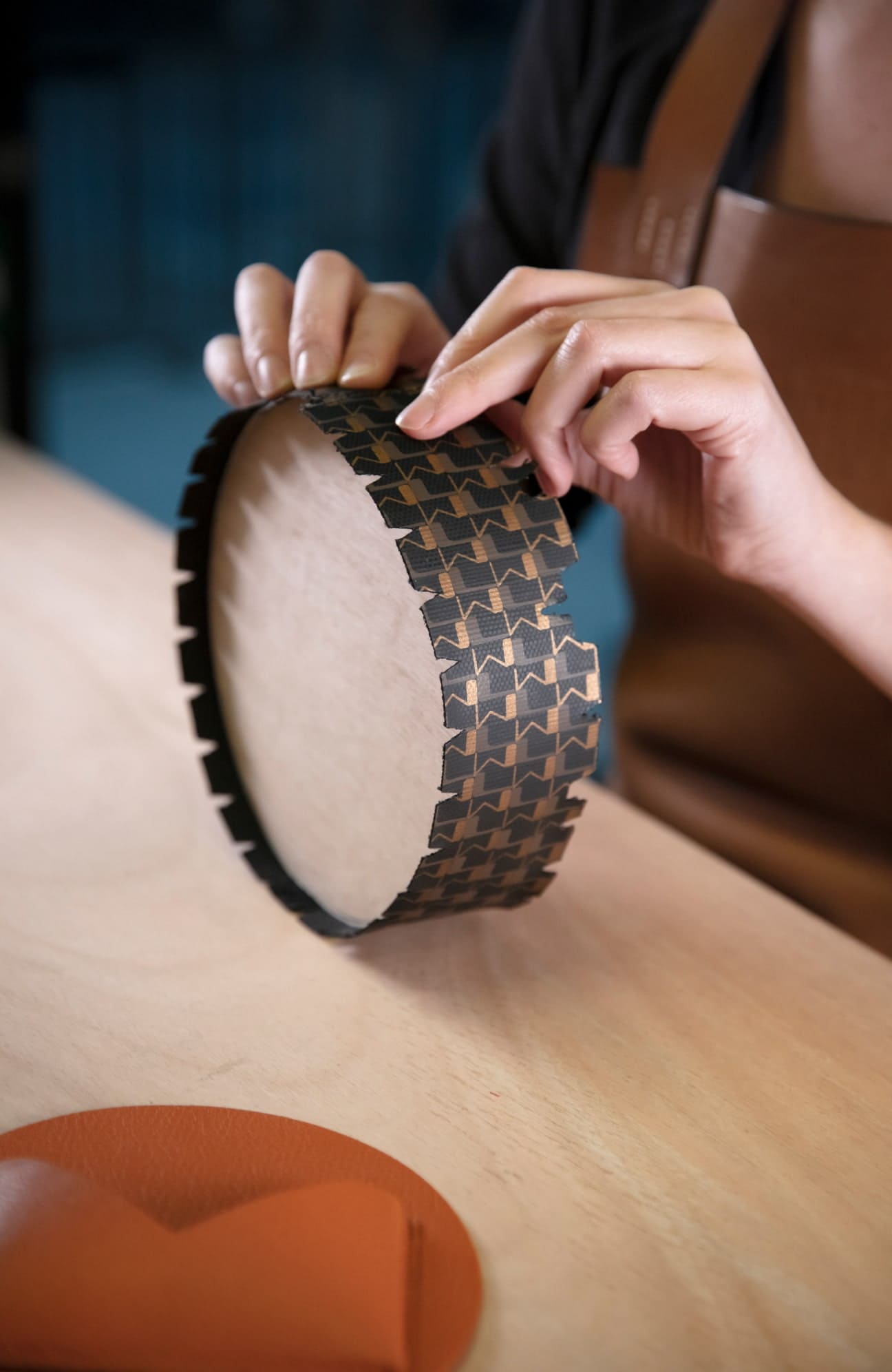 一位工匠在Wheel手袋的提手上涂饰Canvas 1920系列印花 © 艺术指导和场景设计 ARI PHOTOGRAPHY